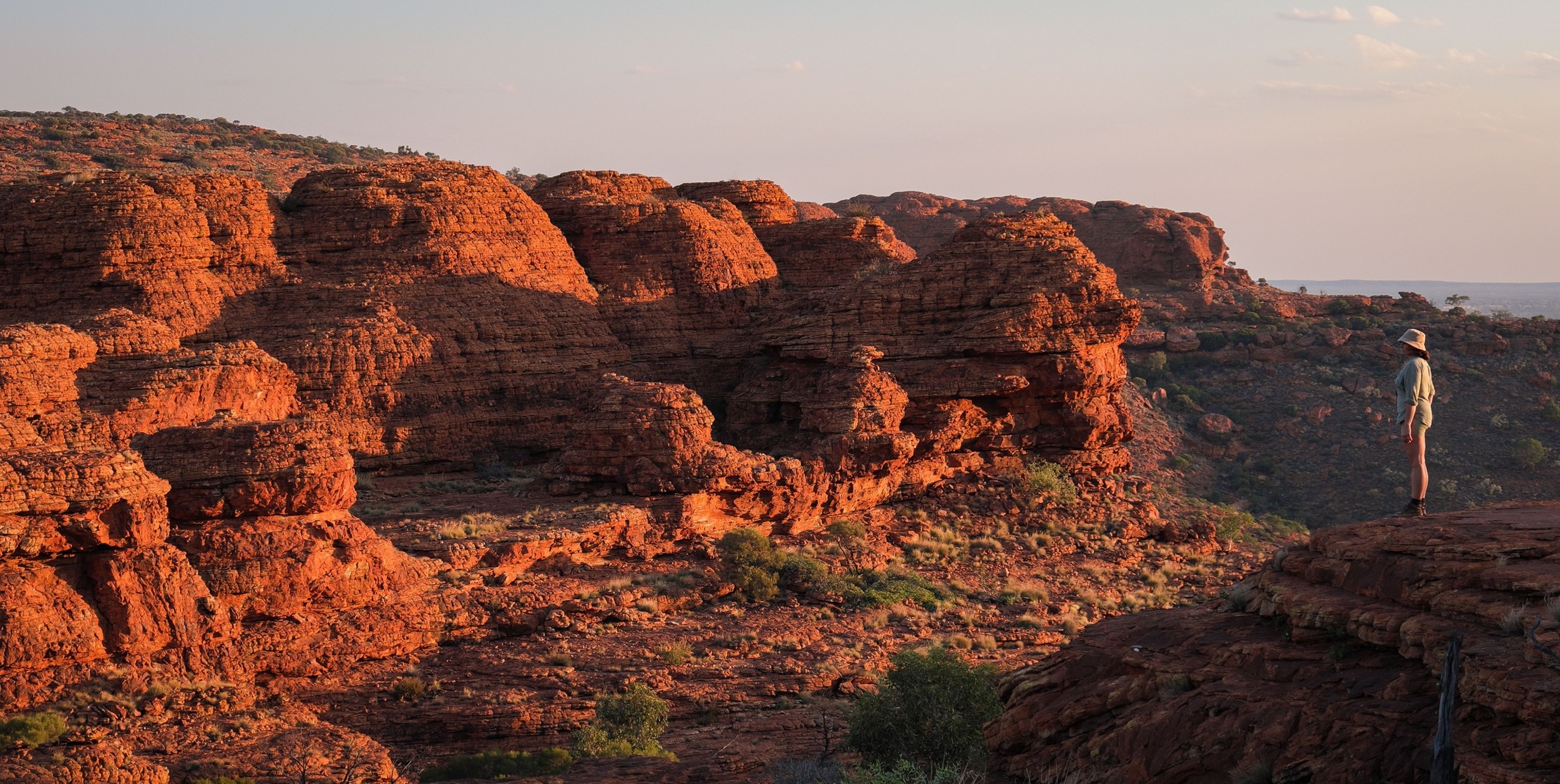 Feel on top of the world as you walk along the towering red rock cliffs of Kings Canyon and take in views of the forest of palms below.Watarrka National Park is only three hours?? drive from Uluru, and is home to the mighty Kings Canyon – a majestic destination featuring 300m high sandstone walls, palm-filled crevices, and views that stretch across the desert.More than just a day trip destination, Watarrka National Park has a range of walking trails, 4x4 tracks, camel tours and accommodation options ranging from camping to resort-style rooms.