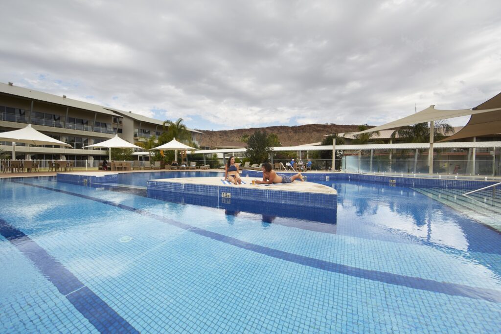 People relaxing by the pool in the Crowne Plaza Alice Springs 